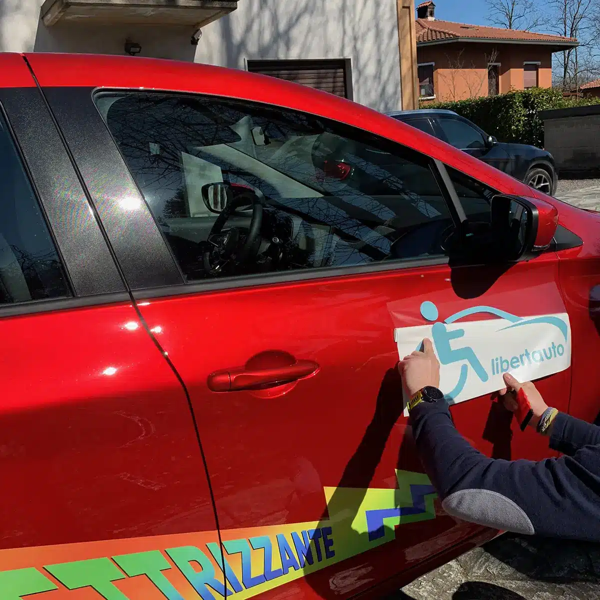 Applicazione di pellicole adesive su auto rossa